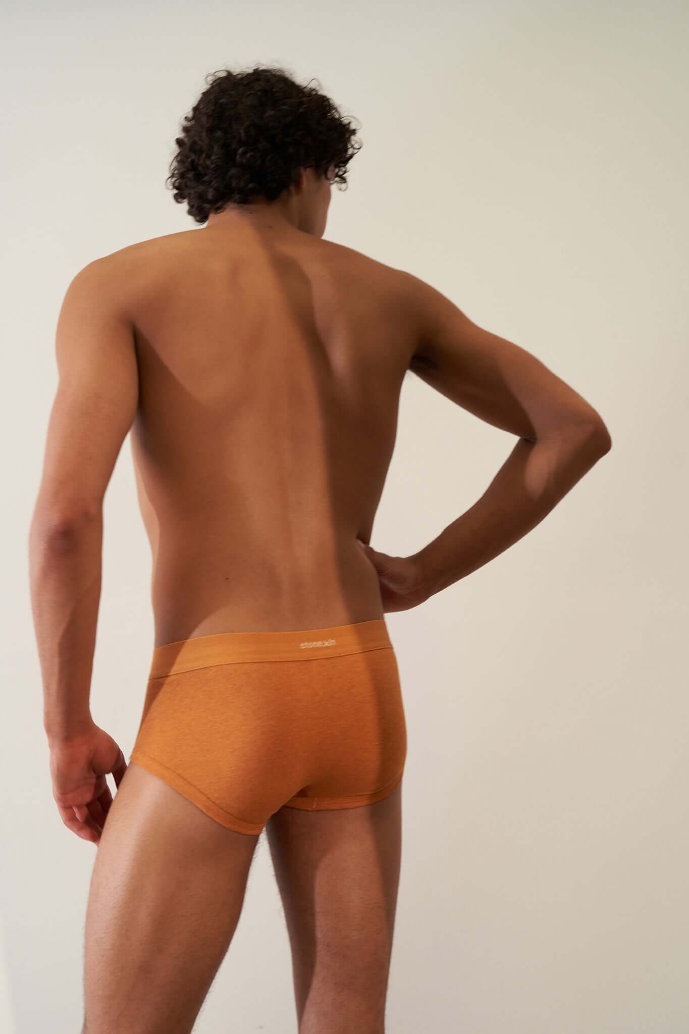 Trunk 3 Pack in Organic Cotton shown on model from the back in papaya color.